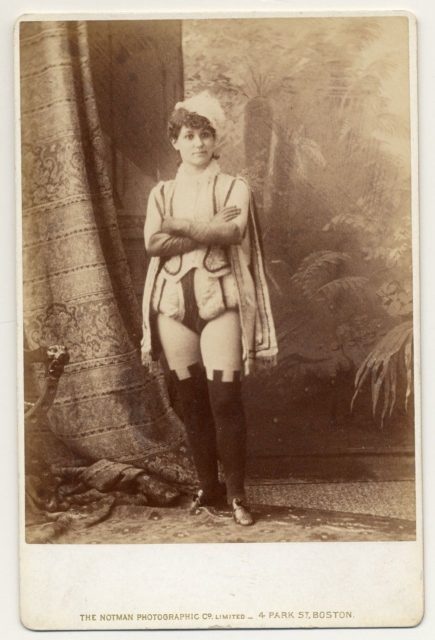 Miss Darcey in short male Renaissance costume with over-the-knee leggings.