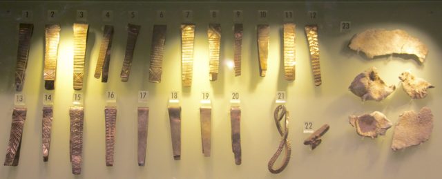 Huxley Hoard. Left: Silver bracelets. 22: One silver ingot. 23: Fragments of lead. Lead wrapped the silver or was part of the box in which the hoard was buried. On display in the Museum of Liverpool.