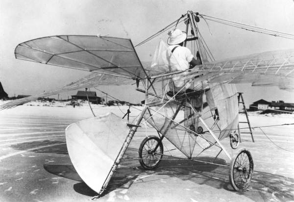Rear view of the wing-flapping, foot-propelled ornithopter with the inventor, George R. White, at the controls on the beach at St. Augustine. Source