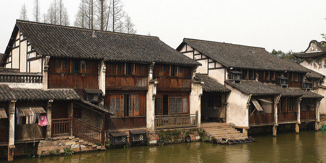 Some of the houses beside the river are built on pillars to lift them above the surface of the waterway. By Jim Bowen/Flickr/CC BY 2.0