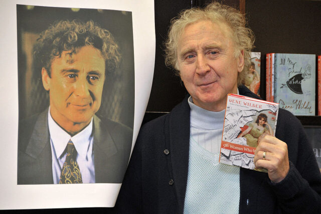 Gene Wilder holding up his book, 'The Woman Who Wouldn't'