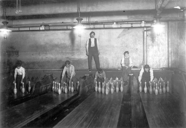1-00 A.M. Pin boys working in Subway Bowling Alleys, 65 South St., Brooklyn, New York, Lewis Hine photo. Source: Wikipedia/Public Domain