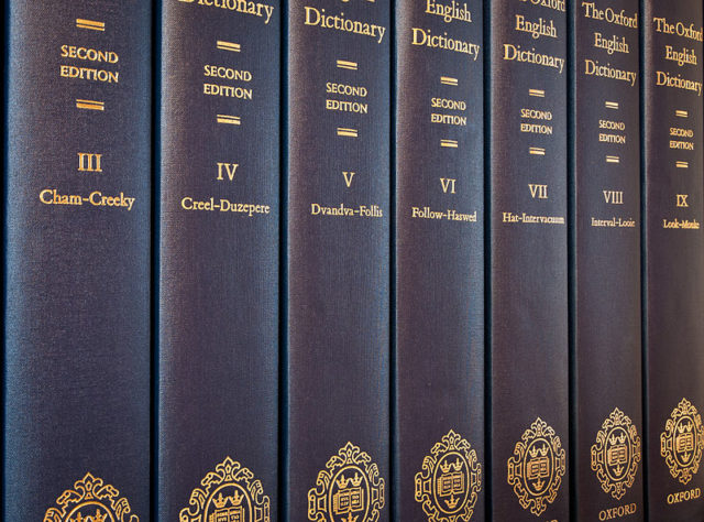 Seven of the twenty volumes of the printed version of the second edition of the OED. By Dan (mrpolyonymous on Flickr) - https://www.flickr.com/photos/mrpolyonymous/6953043608, CC BY 2.0, https://commons.wikimedia.org/w/index.php?curid=40571506