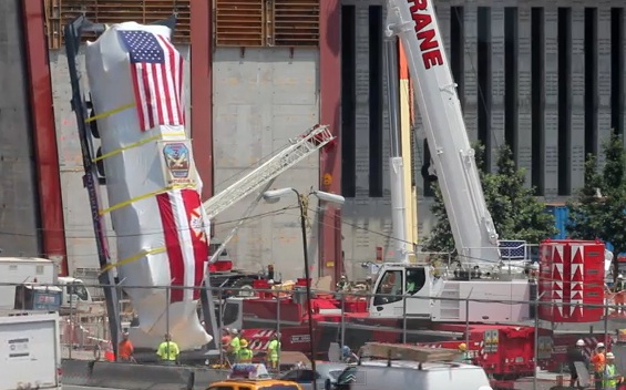 Sheathed in plastic and US and FDNY flags, workers prepare to lower Ladder 3’s apparatus into the National September 11 Photo Credit