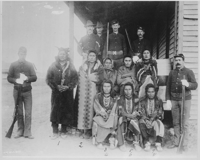 Eight Crow prisoners under guard at Crow agency, Montana,