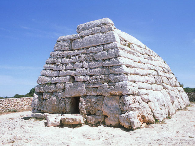 Façade and side wall of the Naveta d'Es Tudons. Photo Credit