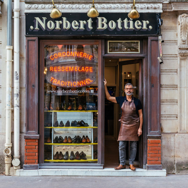 Norbert proudly displays the collection of shoes he designs 