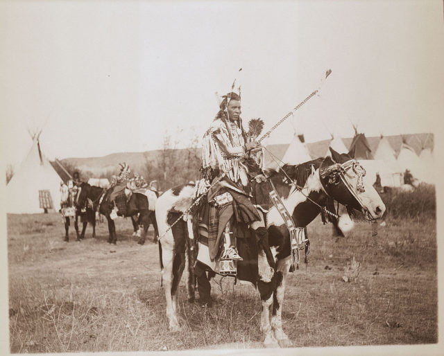 Spotted Rabbit (Crow tribe) on horseback, Montana.