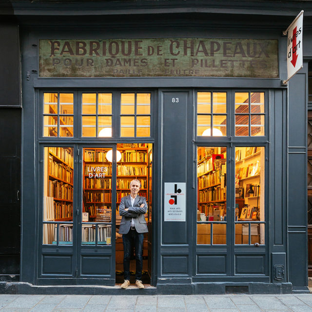 Stefan Perrier, in front of what looks like a hat shop, but is in fact a leading art bookshop