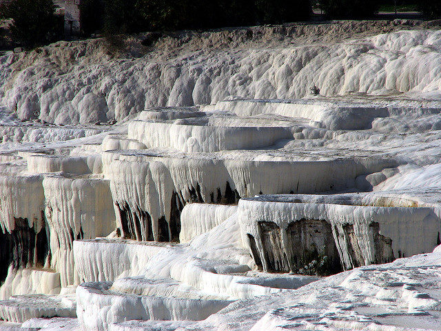 The remains of the ancient Hierapolis are situated on back of the thrilling white terraces, standing wondrously in the area. Photo Credit