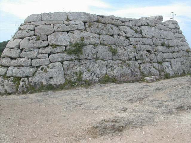 The tomb is 'naveta' (Ship in Spanish) because from the outside it resembles an overturned ship. Photo Credit