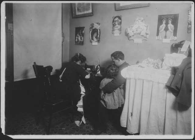 Mrs. Ricca, making rompers for Campbell kids. Husband out of work. New York City, December 1911 Photo Credit