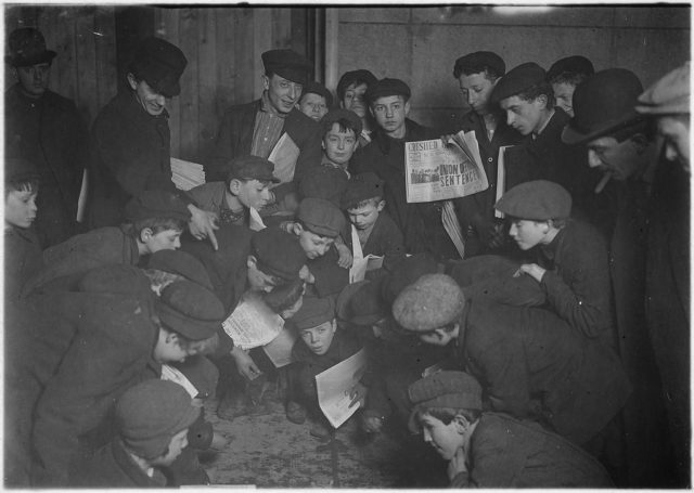 Amusing themselves while waiting for morning papers. New York, February 1908 Photo Credit