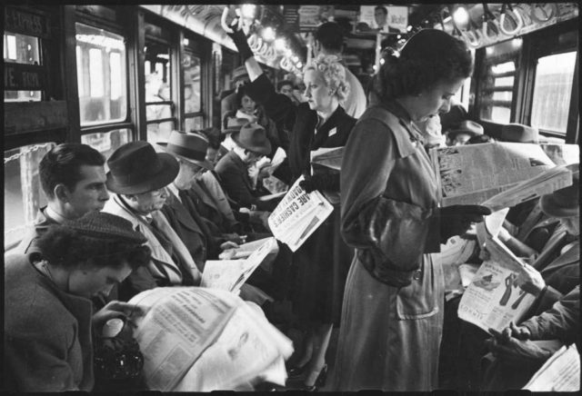 Passengers reading in a subway car Photo Credit