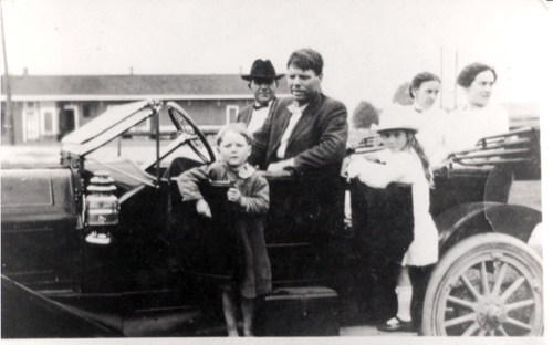 The child raised as Bobby Dunbar standing in front of a car.