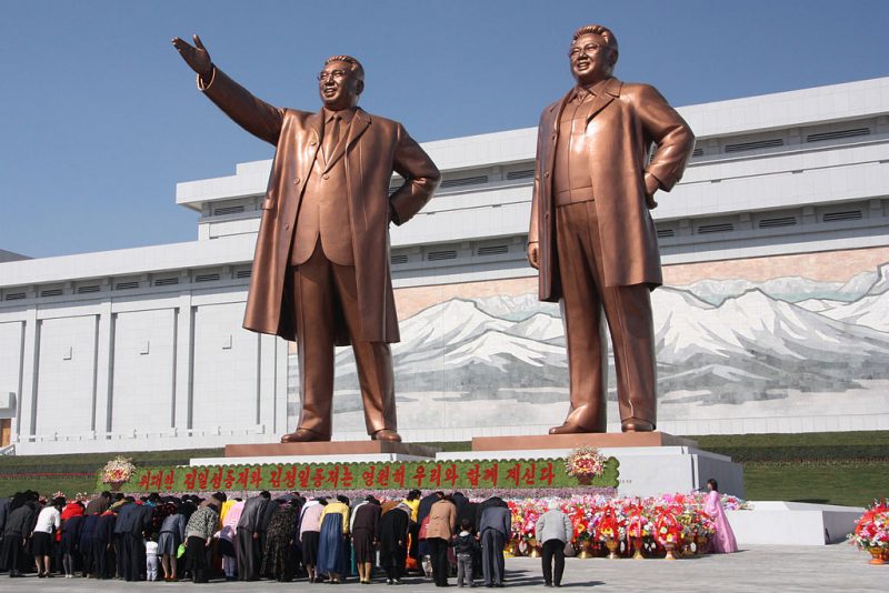 North Koreans bowing in front of statues of Kim Il-sung (left) and Kim Jong-il. Photo Credit