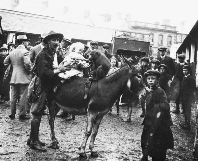 An animal wrangler with Buff Bill’s Circus introduces a child to a baboon c 1910 Photo Credit