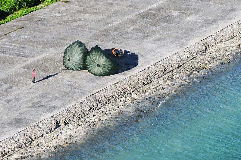 A resident of Mokil Atoll waves to the C-130 crew after receiving an air dropped aid package, 2012.