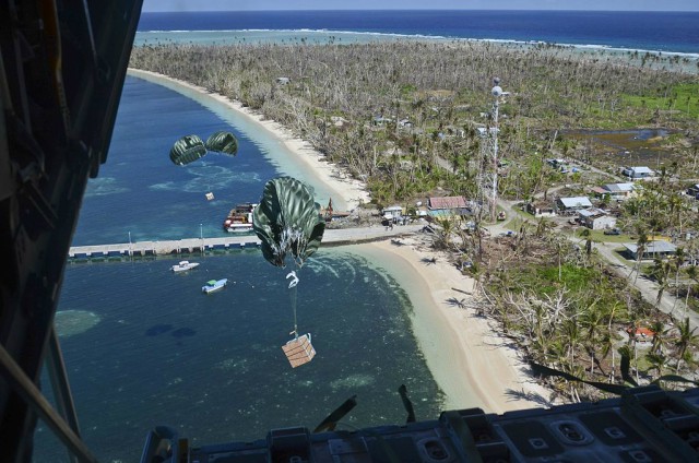 Cargo drops from a U.S. Air Force C-130 Hercules aircraft over the Pacific Ocean toward a landing zone on the shore of Kayangel Island during the 62nd annual Operation Christmas Drop Dec. 11, 2013. 