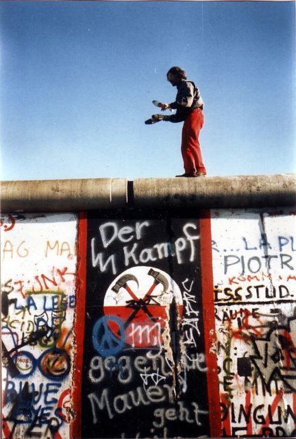 The black, white and red graffitti banner on the wall below the juggler depicts a pair of marching hammers, an allusion to the film Pink Floyd The Wall.. Photo Credit