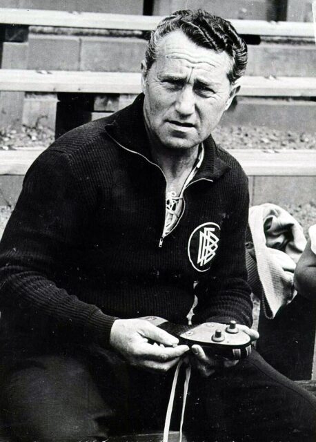 Dassler holding up a pair of his shoes