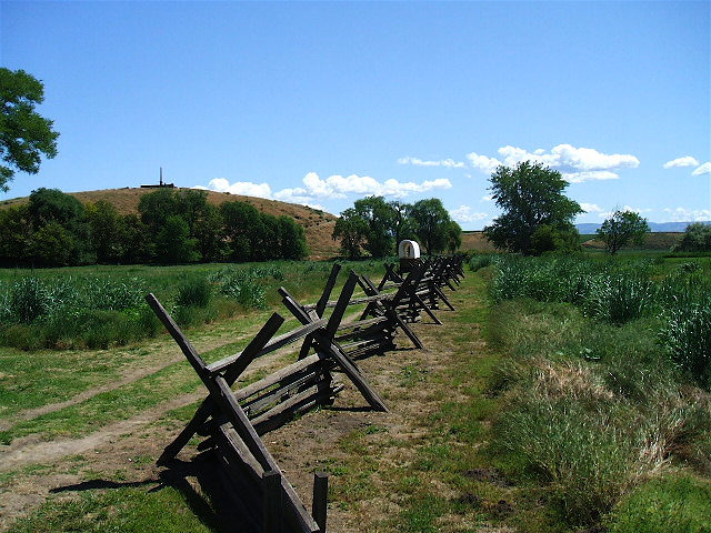 Covered wagon replica and Mission Monument at the Whitman Mission National Historic Site about ten miles west of Walla Walla, Washington