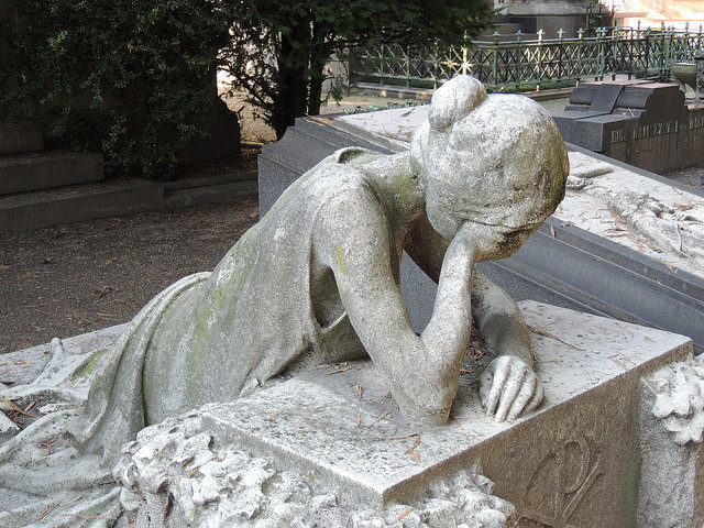 A sculpture of a weeping woman on one of the graves at the cemetery. Photo Credit