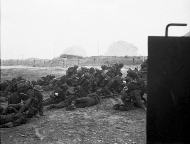 British troops take cover after landing on Sword Beach.