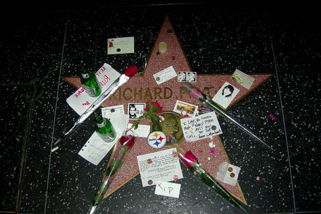 Richard Pryor’s star on the Hollywood Walk of Fame covered with flowers, beer bottles, and fan letters  Photo Credit