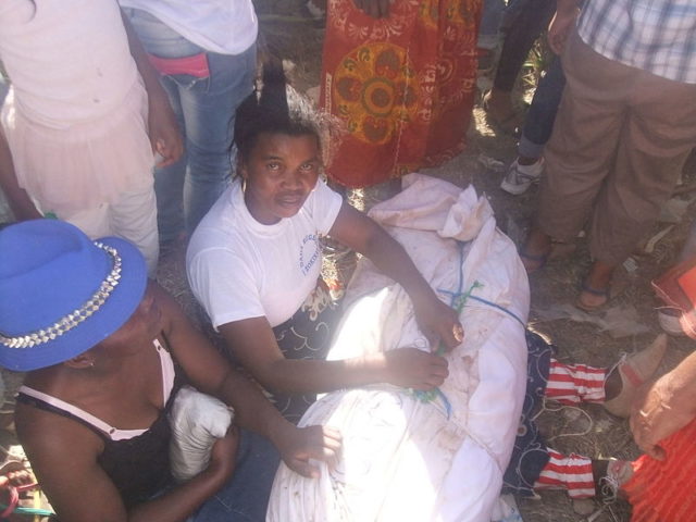 Women preparing to wrap a dead body in fresh cloth. Photo Credit