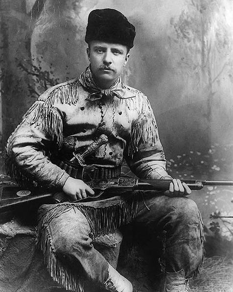 Theodore Roosevelt in 1885 with his highly decorated deer-skin hunting suit, Tiffany-carved hunting knife, and rifle