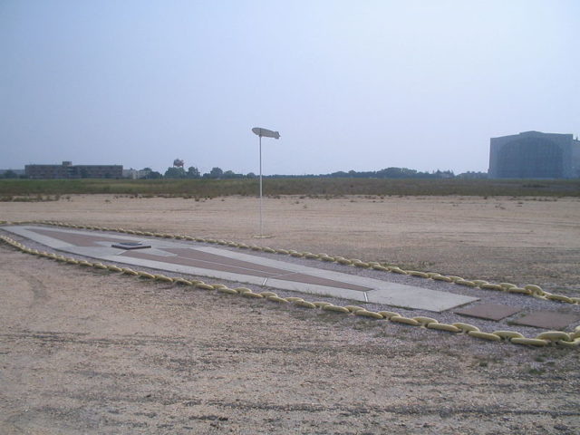 Current marker at the disaster site, shown with Hangar No. 1 in background Photo Credit