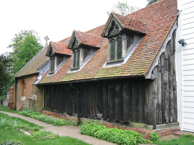 The less photographed northern side of this famous Anglo-Saxon church. The unusual vertical split oak log construction can be seen clearly  Photo Credit