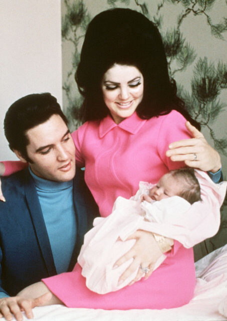 Elvis and Priscilla Presley sitting with Lisa Marie