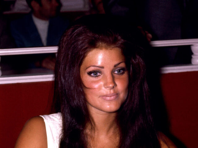 Priscilla Presley sitting in a red booth