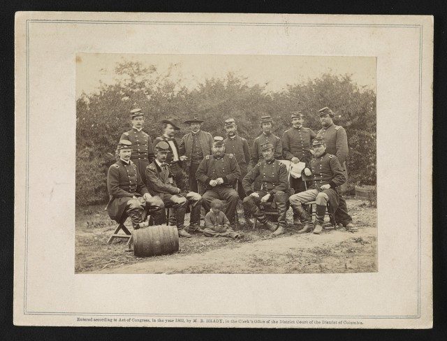 Photograph shows a group portrait of Generals Andrew A. Humphreys, Henry W. Slocum, William B. Franklin, William F. Barry, and John Newton, with an African American boy at Cumberland Landing, Virginia. Photo Credit