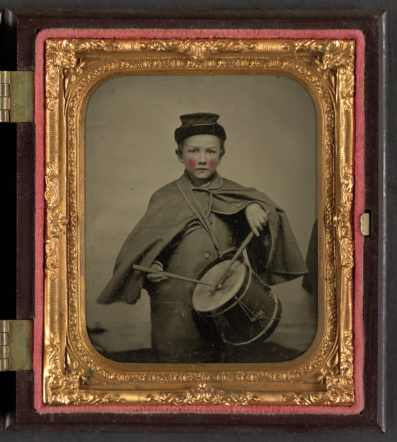 Unidentified young drummer boy in military uniform playing drum. . LOC