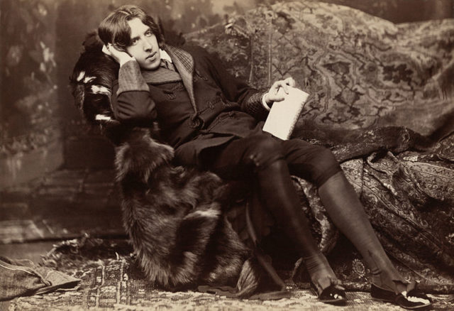 Oscar Wilde reclining with Poems, by Napoleon Sarony in New York in 1882. Wilde often liked to appear idle, though in fact he worked hard; by the late 1880s he was a father, an editor, and a writer.