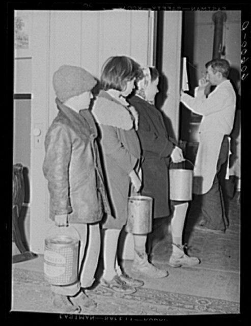 Children are waiting in a line for soup given out each night by the city mission, a community chest- financed organization. Dubuque, Iowa  Photo Credit