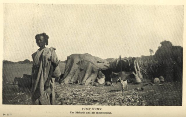 Bisharin tribesman stands in front of his camp. Author: Sladen, Douglas  CC BY-SA 2.5