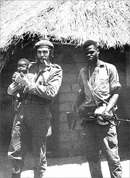 Che Guevara holding a local infant in Congo, during the Congo crisis in 1965. On his left a fellow Congo soldier