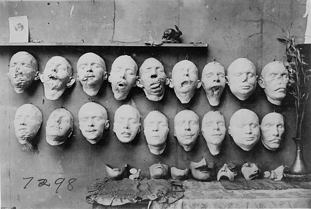 Facial masks lined up in two rows on a wall