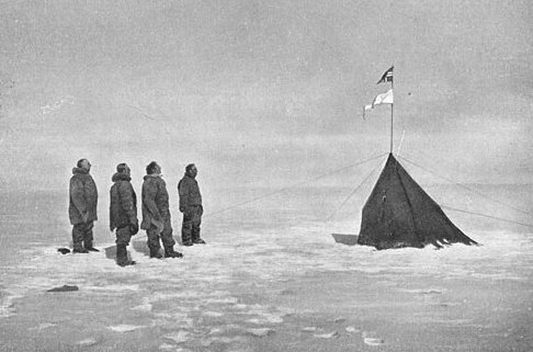 Roald Amundsen and his crew looking at the Norwegian flag at the South Pole, 1911.