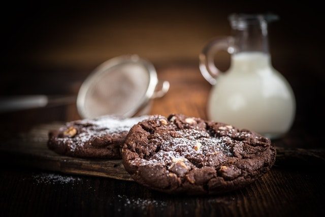 A photo of freshly baked chocolate chip cookies served with milk