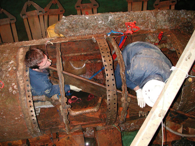 Removing the first section of the crew’s bench at the Warren Lasch Conservation Center, January 28, 2005. (Photograph courtesy the U.S. Naval Historical Center.)