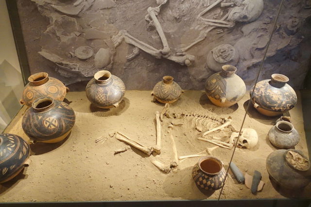 Burial site reconstruction, Bianjiagou, Liaoning province, China. Neolithic Yangshao culture, ceramic pots, grindstones, human skeleton – Östasiatiska Museet, Stockholm