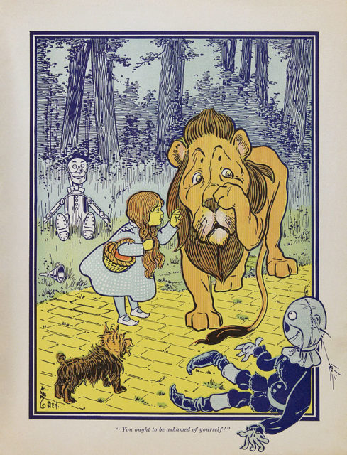 Dorothy and her companion, Toto, befriend the Cowardly Lion while traveling on the Yellow Brick Road, as drawn in the first edition of the novel.