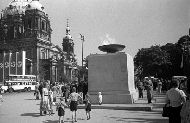 The Olympic Fire in Berlin during the 1936 Games, and in the background a mass display of Nazi flags. Photo by Josef Jindřich Šechtl, CC-BY 2.5.