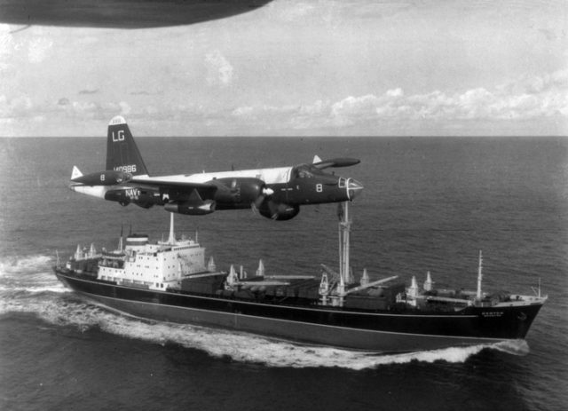 A U.S. Navy P-2H Neptune of VP-18 flying over a Soviet cargo ship with crated Il-28s on deck during the Cuban Crisis.