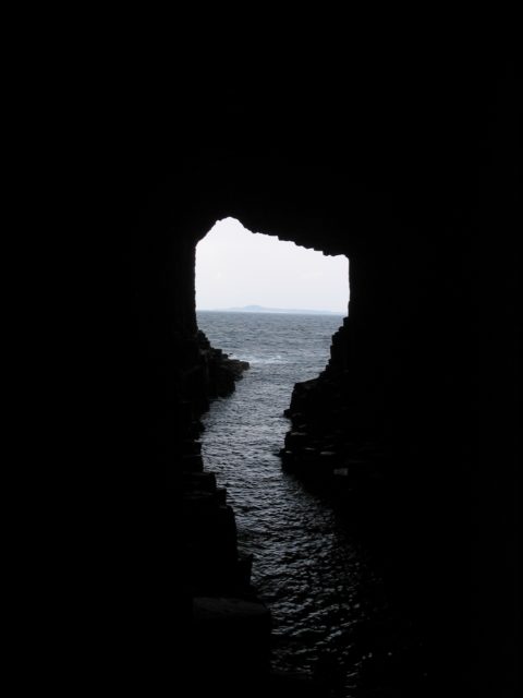 View from the depths of the cave with the island of Iona visible in the background, 2008. Internal view of Fingal’s Cave on the island of Staffa, with a view across the open sea to the island of Iona, both are islands of the Inner Hebrides in Argyll and Bute, Scotland. Author: N2e; CC BY-SA 3.0